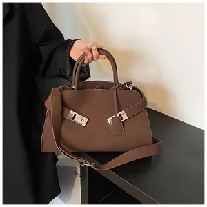 Detailed shot of dark brown tote bag featuring silver buckle and detachable shoulder strap