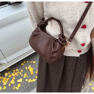 Détail du sac nuage plissé marron foncé avec poignée nouée et bandoulière en cuir