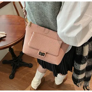 Détail du sac à bandoulière en velours côtelé rose clair avec un fermoir rotatif en métal