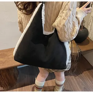Détail du grand sac cabas en daim noir avec bordure en laine de mouton blanche et pull beige