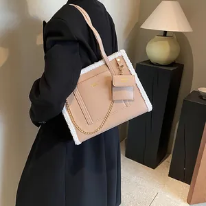 Beige faux leather tote bag with white faux fur trim and gold chain detail on model