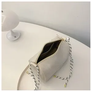 Detailed interior view of the beige cylindrical crossbody bag with metal zipper closure
