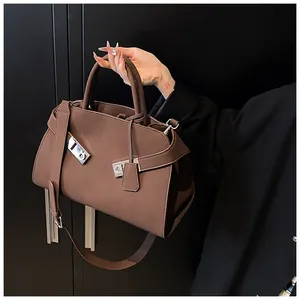 Detail of classic brown leather handbag with silver buckles and adjustable wide strap