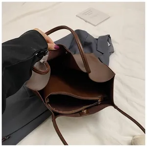 Interior detail of large brown tote bag showing zipper pocket and magnetic snap closure
