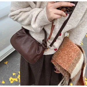 Vue détaillée du sac bourse marron foncé plissé avec poignée à nœud décoratif