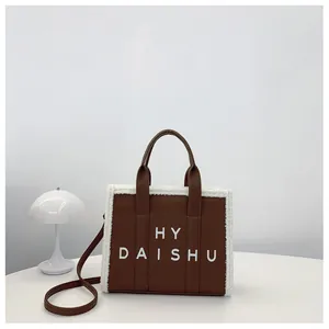 Dettaglio della borsa tote marrone scuro con bordo in ecopelliccia e scritta HY DAISHU