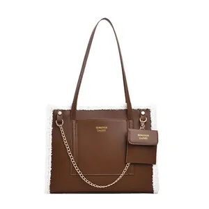Brown leather tote bag with white faux fur trim and matching small pouch accessory
