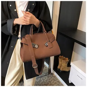Detail of dark brown matte leather tote bag with silver hardware and adjustable strap