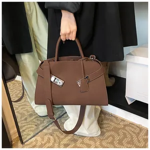 Detail of dark brown tote bag with silver buckle and cylindrical handle for women