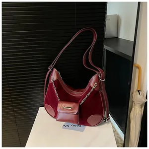 Detalle del bolso tote burdeos con patchwork de cuero y ante y cadena plateada