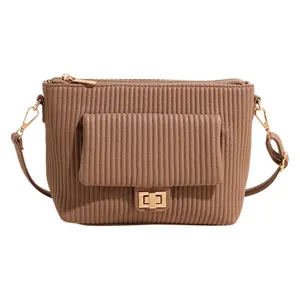 Sac bandoulière plissé marron avec ferrures dorées et poche frontale sur fond blanc