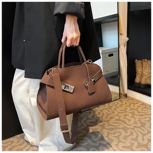 Brown leather crossbody tote featuring dual handles and silver metallic buckle details