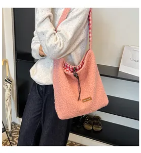 Detail view of pink plush bucket bag showing drawstring closure and checkered lining