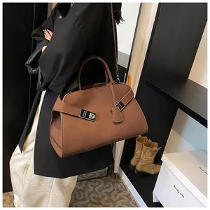Detail shot of the brown vintage tote bag showing its matte leather texture and silver buckle