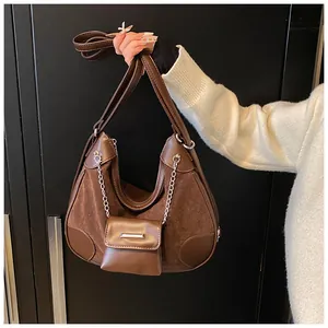 Detalle de un bolso hobo retro marrón oscuro con patchwork de ante y cadena de plata