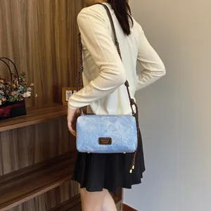 Blue stonewashed canvas shoulder bag with thick rope strap shown on model in cozy interior
