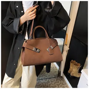 Detail of dark brown leather tote bag with silver Gancini style buckles and handles