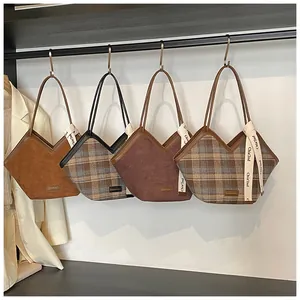 Detailed comparison of four plaid and suede tote bags hanging on metal wall hooks
