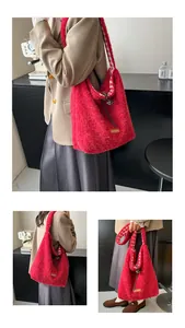 Detail of red faux fur tote bag with checkered lining and a brown leather label