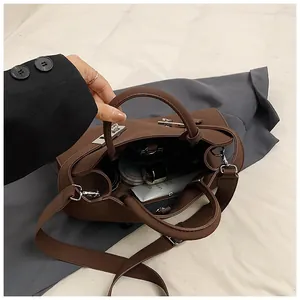 Detail view of brown leather bag interior showing silver lock and storage space