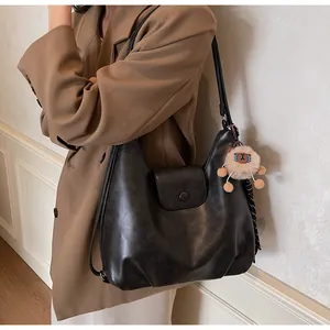 Dettaglio della borsa tote nera vintage con un ciondolo a forma di alpaca sul lato