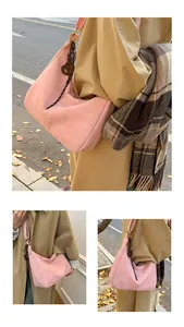 Close-up of pink suede half-moon crossbody bag featuring a wooden heart charm detail