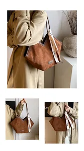 Detail of vintage brown suede tote bag with V-cut edge and stylish decorative ribbon strap