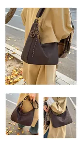Detail of dark brown tote bag with decorative wooden ring and woven rope strap detail