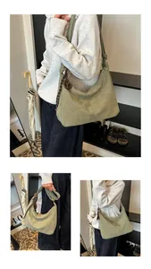 Detail view of large light green suede tote bag with woven rope and round pendant