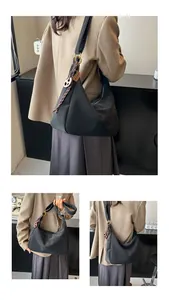 Detailed views of a black crescent tote bag with wide straps and gold hardware