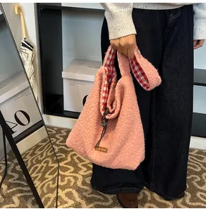Detail view of pink plush bucket bag showing soft shearling fabric and red plaid lining