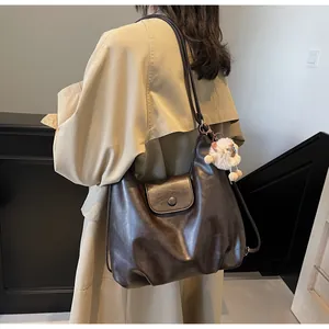 Dettaglio della borsa a tracolla marrone scuro vintage con ciondolo a forma di agnellino