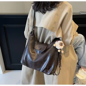 Vista dettagliata della grande borsa tote in pelle marrone scuro con ciondolo a pecora