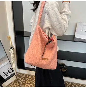 Detail of soft pink faux fur bucket bag featuring drawstring closure and inner plaid lining