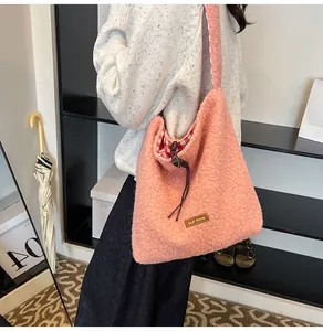 Detail view of pink plush tote bag with red checkered lining and our fave leather label