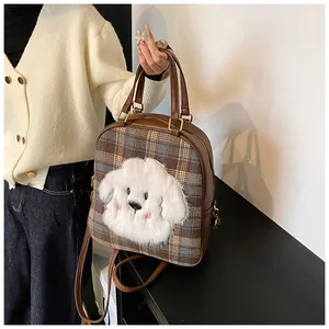 Detail of checkered tote bag featuring a cute plush puppy charm and versatile straps
