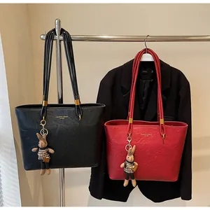 Détails de grands sacs fourre-tout en noir et rouge avec texture cuir et charms lapin