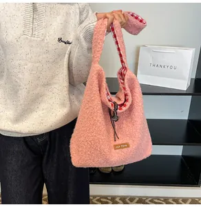 Detail of pink faux shearling bucket bag featuring red gingham lining and drawstring closure