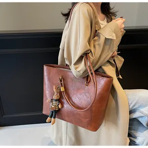 Détail du grand sac cabas en cuir marron vintage avec logo doré et charm lapin mignon