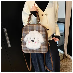 Detail of checkered tote bag with cute plush puppy patch and adjustable brown strap