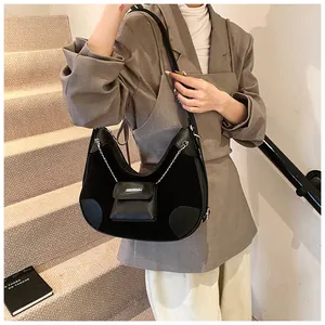 Detalle del bolso media luna negro con patchwork de ante y monedero de cadena plata