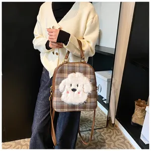Detail of vintage brown plaid tote with cute plush puppy patch and adjustable straps