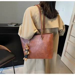 Détail du sac cabas vintage en cuir souple avec lettrage doré et charm de lapin