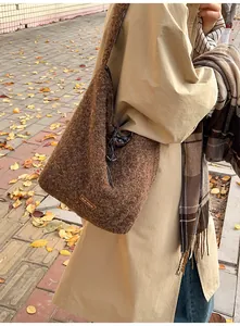 Detail of a brown faux shearling bucket bag featuring an our fave leather brand patch