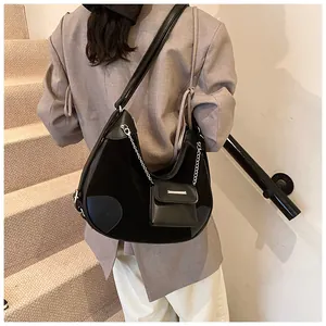 Detalle del bolso hobo de ante negro con colgante y herrajes plateados