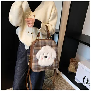 Detail of checkered tote bag featuring a cute plush puppy embroidery and PU leather straps