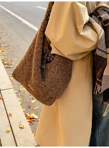 Detail of plush brown hobo bag featuring 'our fave' leather tag and checkered lining