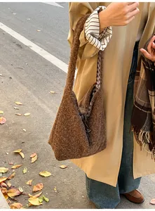 Close-up of deep brown plush bucket bag texture with check lining and drawstring detail