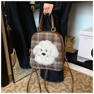 Detail of checkered tote bag featuring a cute white plush dog motif and leather straps