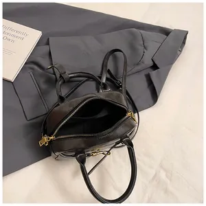 Interior view of black vintage handbag showing a zipper pocket and gold hardware